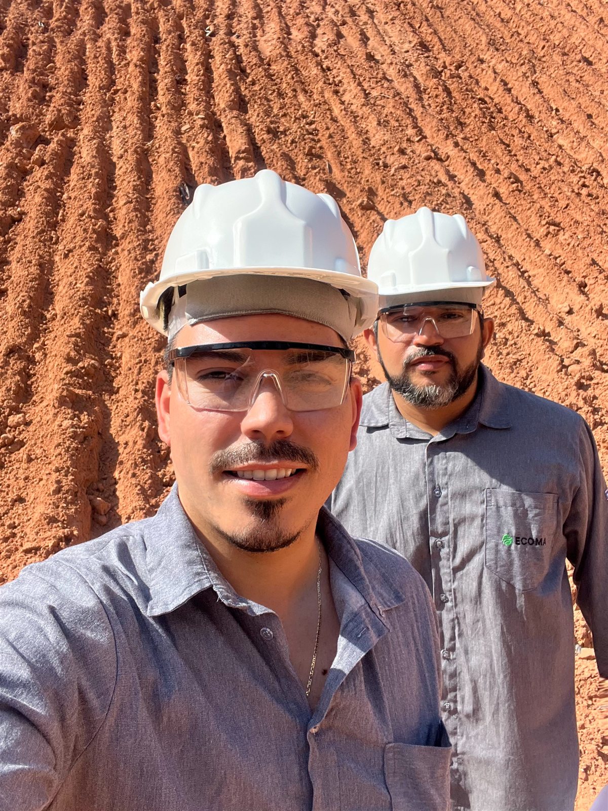 Equipe ECOMA em área de obra com capacetes